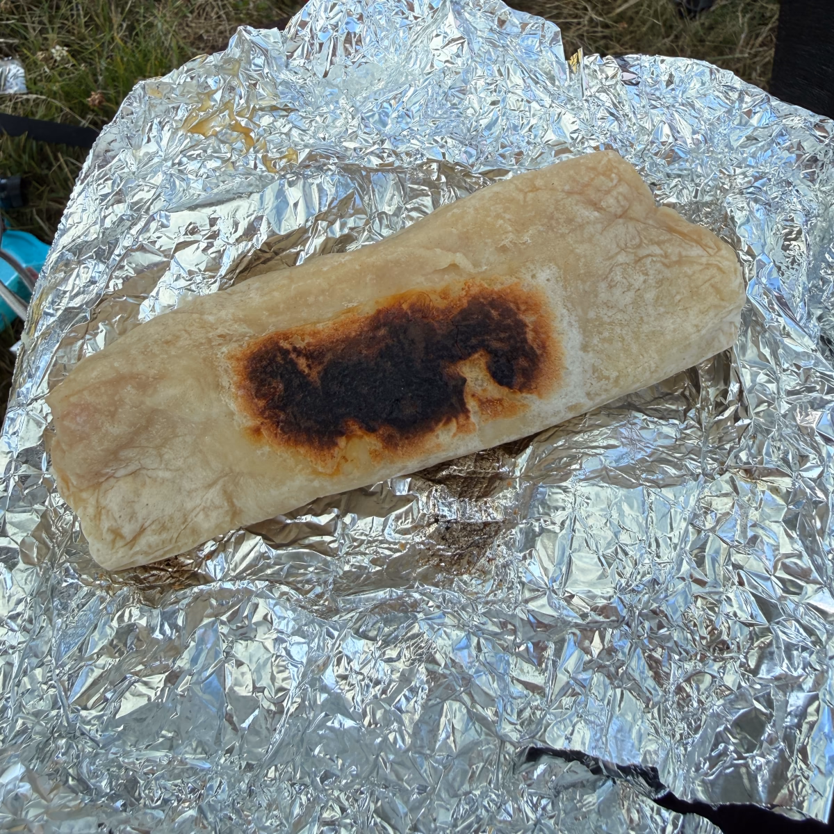 A burrito with a dark char on its tortilla